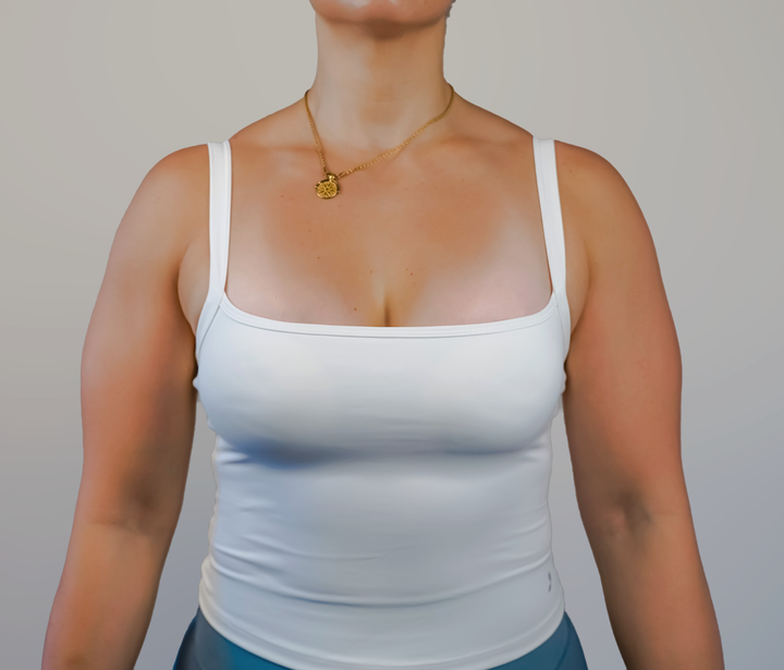 Person wearing a white tank top against a plain background
